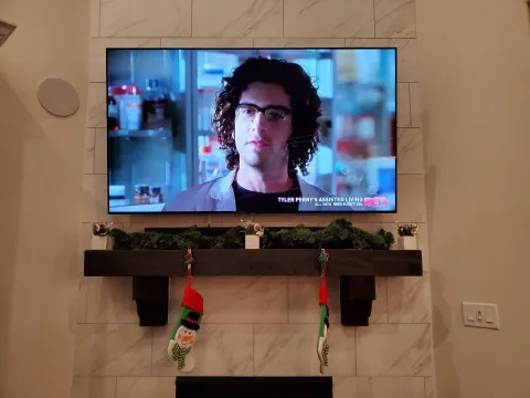 Wall-mounted TV over a marble fireplace with concealed wiring